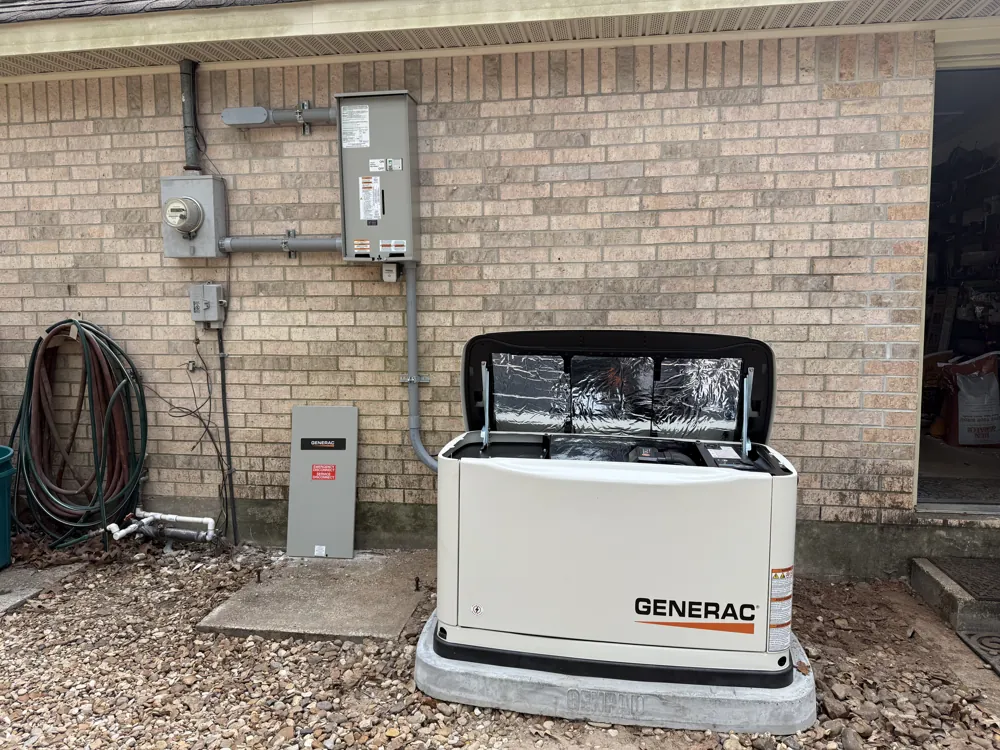 Residential standby generator beside outdoor electrical service equipment