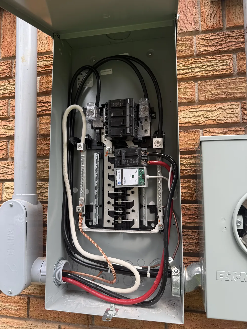 Open outdoor residential electrical panel photographed during panel work